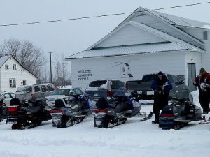 Snowmobiles parked in a line at the Bellsite Community Centre.
